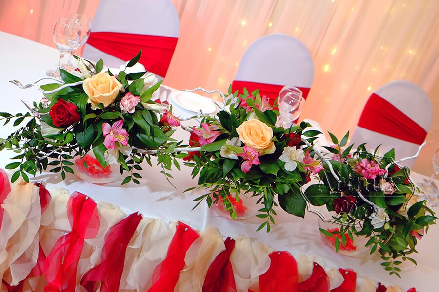 Цветы в вазе на свадебном президиуме для молодоженов