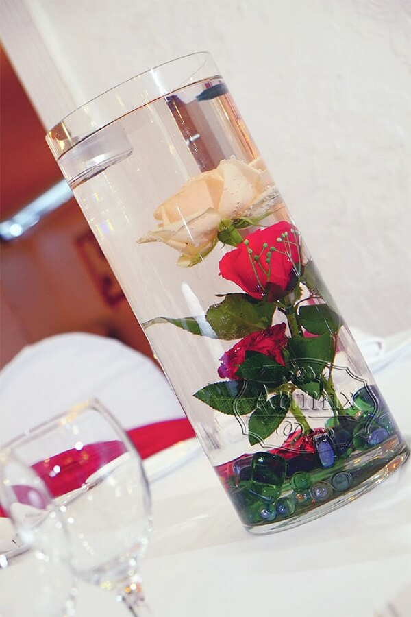 Прозрачная ваза с одиночно вертикально стоящими розами