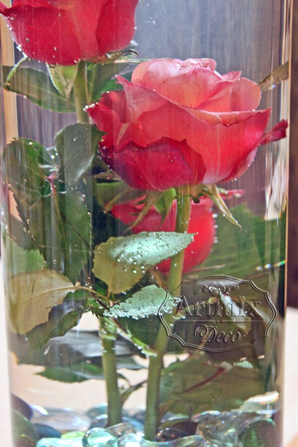 Красные розы в воде на свадебном торжестве