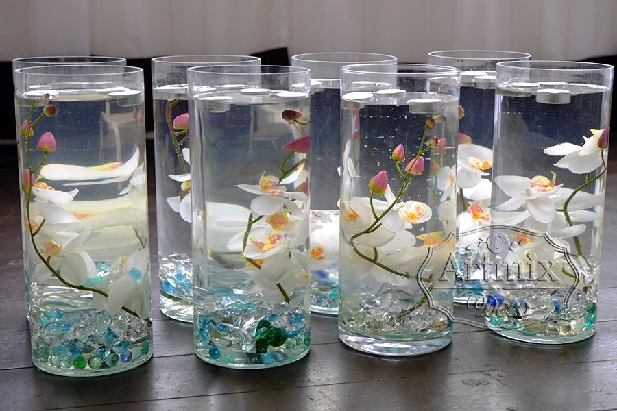 Свечи в стеклянных вазах с цветами