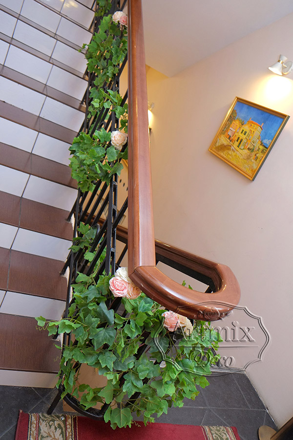Романтичным вариантом декорирования лестницы является украшение в виде пышной гирлянды из  цветов и зеленью