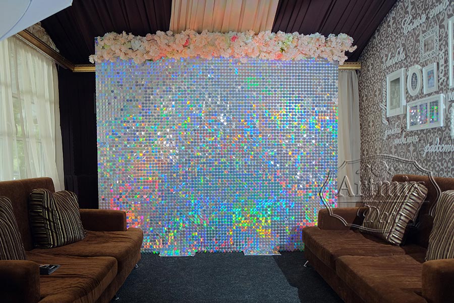 Оформление фотозоны из перламутровых пайеток с гирляндой из цветов в холле ресторана при усадьбе 