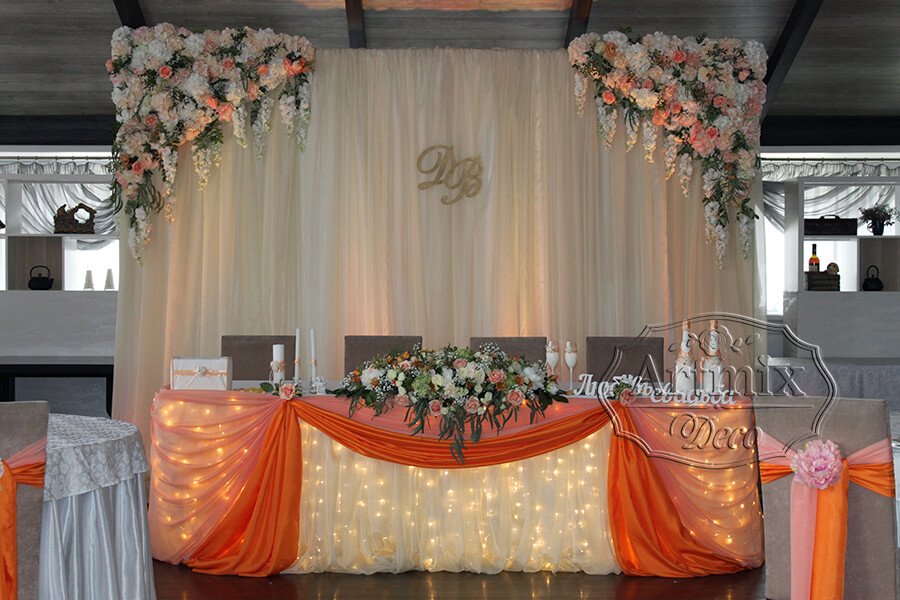 Фон свадебного подиума декорирован из воздушного шифона и по углам треугольные цветочные элементы