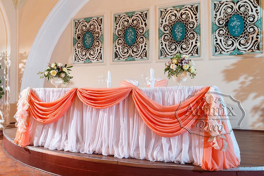 Свадебный президиум оформлен драпировками из нежного шифона персикового и белоснежного цвета