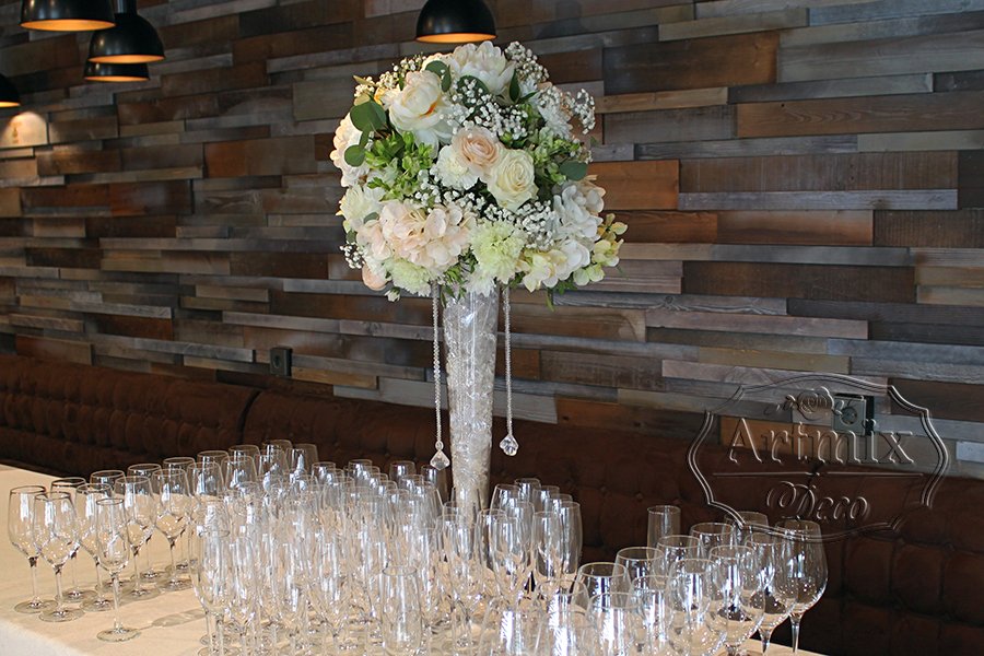 Высокие вазы с цветочными композициями на фуршетном столе