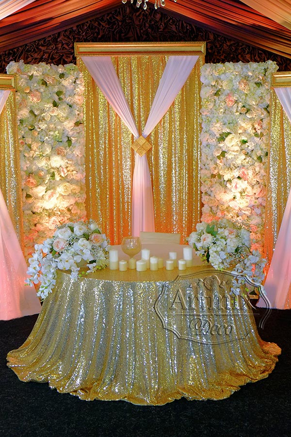 На свадебном президиуме использован дорогой текстиль – золотые пайетки, вертикальное панно из цветов и золотой багет