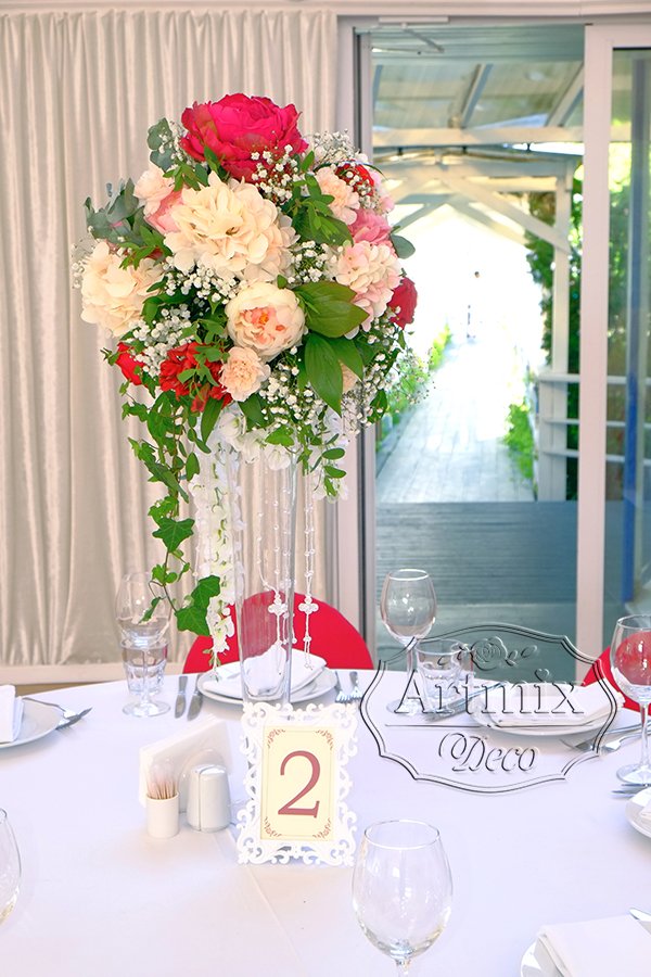 Прозрачная ваза с цветами в центре стола гостей на свадебном банкете
