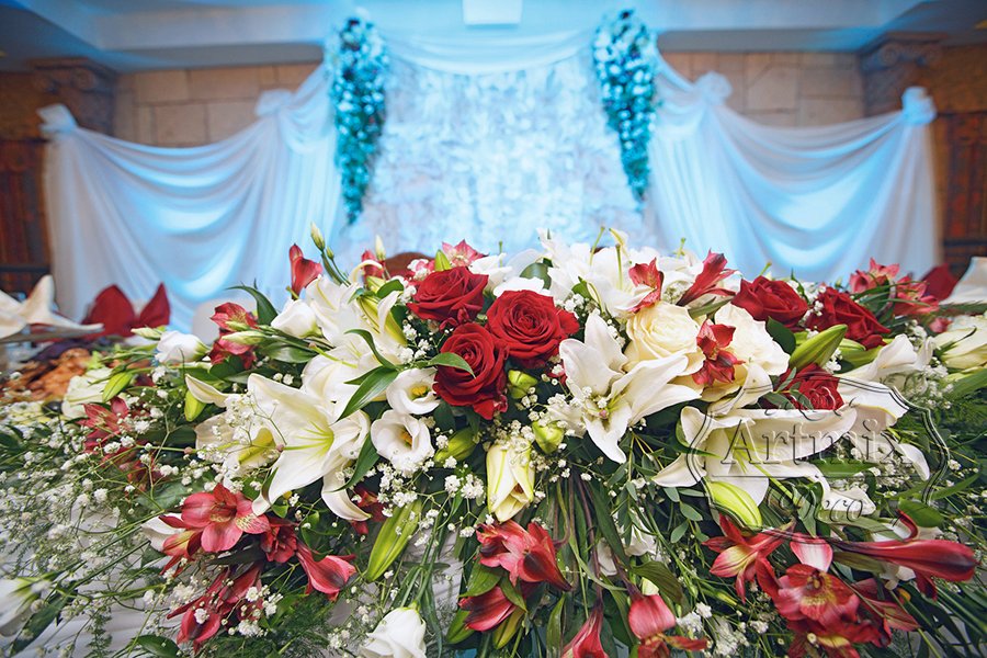 Композиция для свадебного стола с красной розой, белой лилией, эустомы и орхидеи