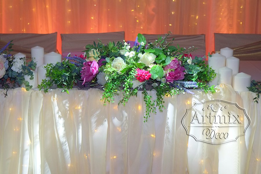 На президиуме жениха и невесты 3 цветочных композиций со свечами