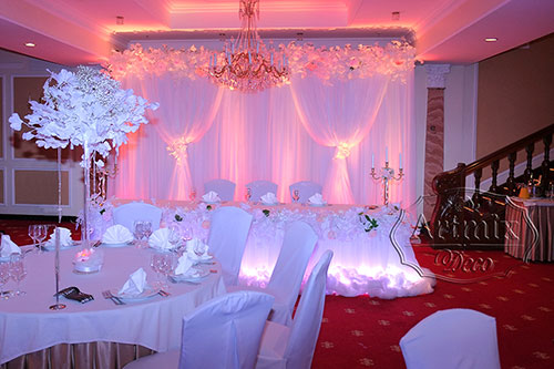 Свадебный фон с подсветкой, гирлянды из цветов, веток Гинкго и золотыми канделябрами