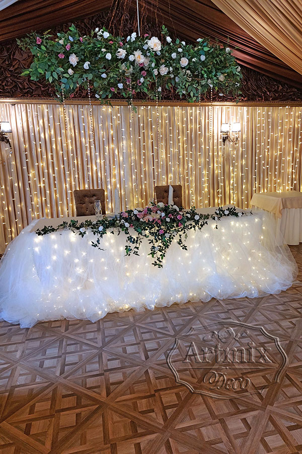 Свадебный фон молодожёнов с цветочной гирляндой над столом