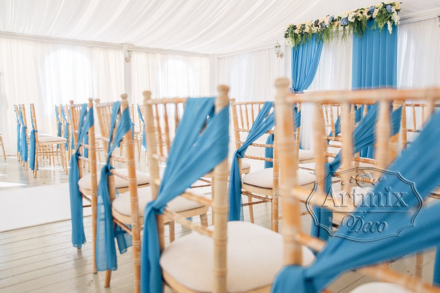 Украшение стульев широкими лентами голубого оттенка для выездной регистрации брака