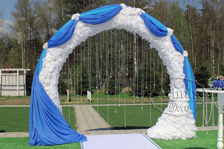 Круглая арка, формы подковы, драпирована легким струящимся шифоном из белоснежной ткани и дополнена голубой драпировкой