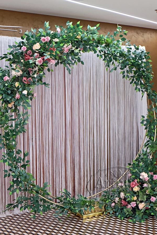 Круглая арка с зеленью и цветами для выездной регистрации брака