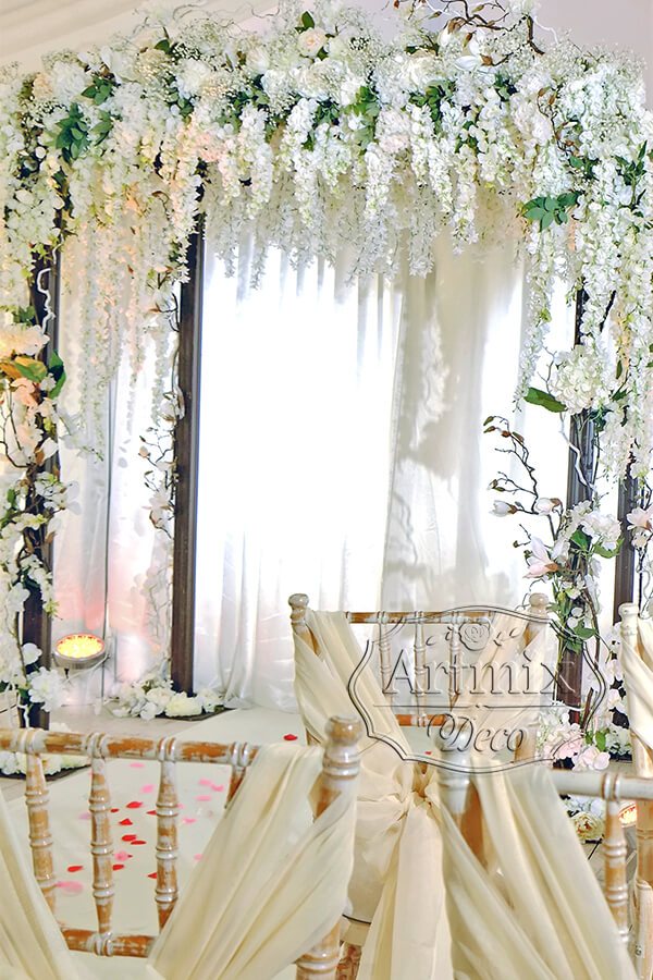 Пышные цветущие белые кисти вистерии в оформлении свадебной арки