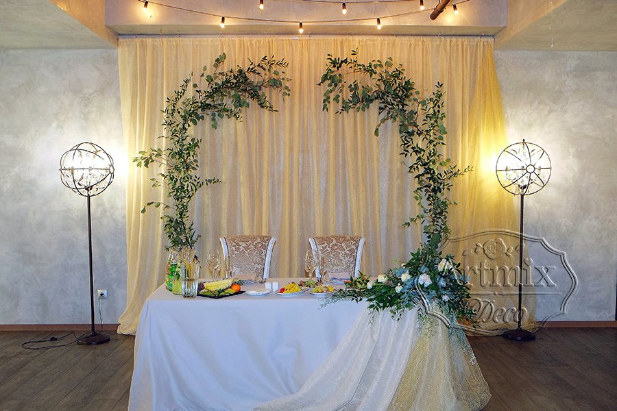 Свадебный президиум оформлен с зелёными ветвями эвкалипта и итальянского рускуса в стиле ЛОФТ