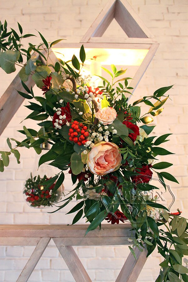 На свадебном фоне цветы на ветках декоративного кореллиуса натурального коричневого цвета
