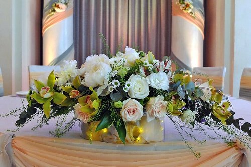 Цветочная композиция с подсветкой выполнена из золотистого цимбидиума, двух сортов роз и шикарных пионов