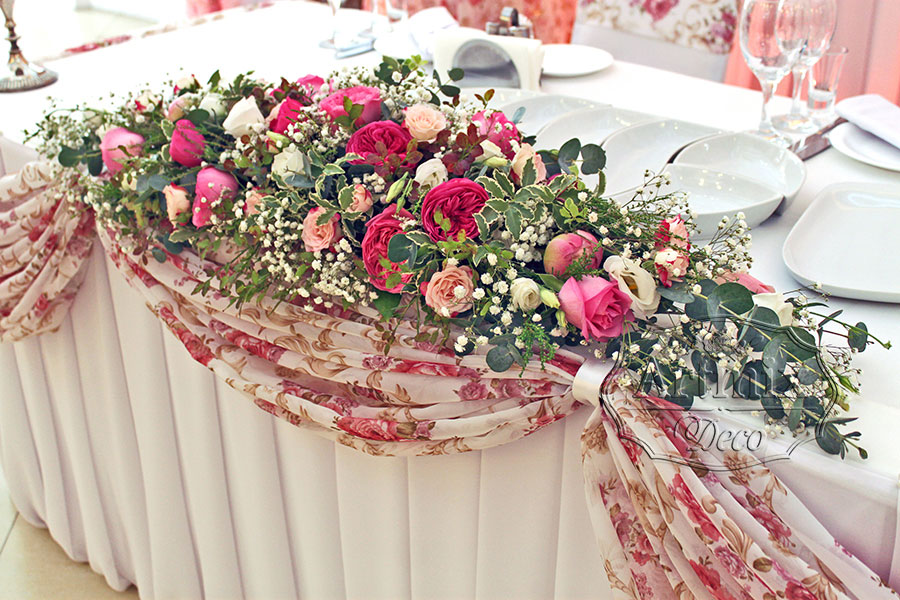 Композиция из пионов, роз и эустомы на столе жениха и невесты