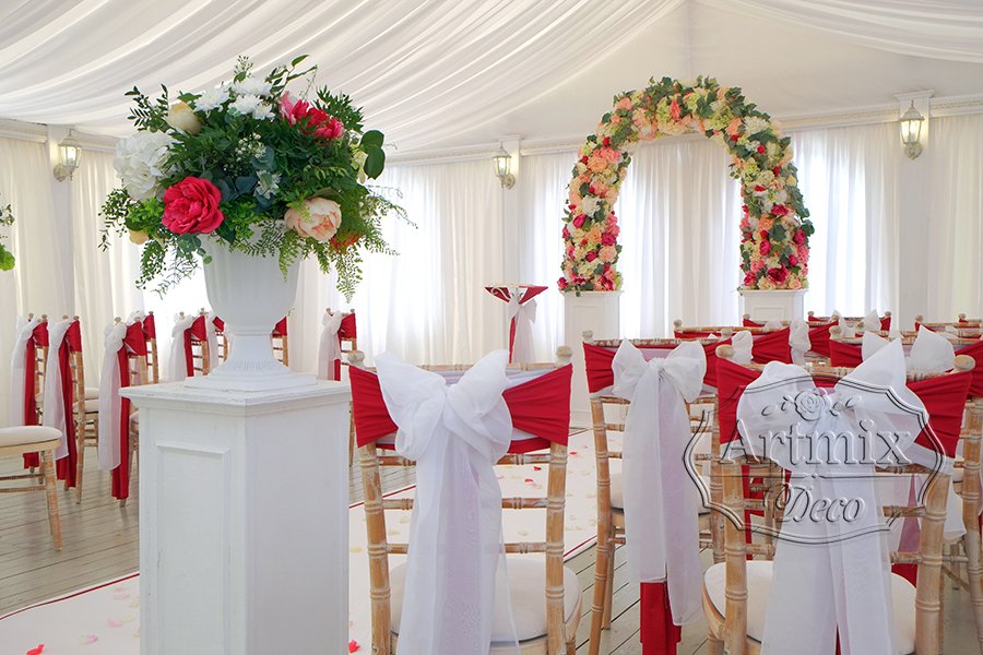 Полукруглая свадебная арка и флористические композиции в вазах, стоящие на белых колоннах